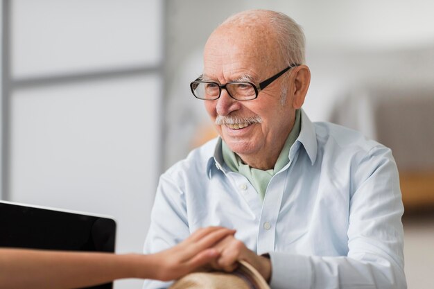 Smiley senior man conversing with nurse