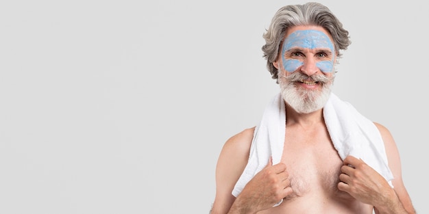 Smiley senior man with face mask and towel