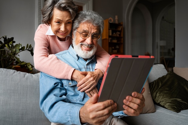 Foto gratuita faccina senior con tablet angolo basso