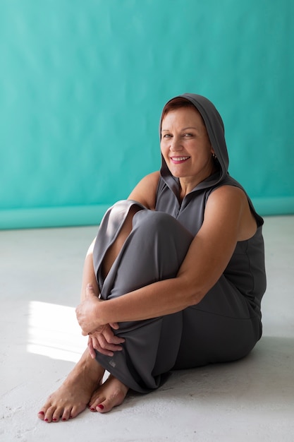 Smiley senior woman sitting on the floor