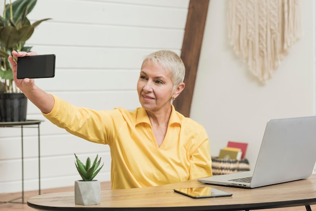無料写真 スマイリー年配の女性、selfieを取る