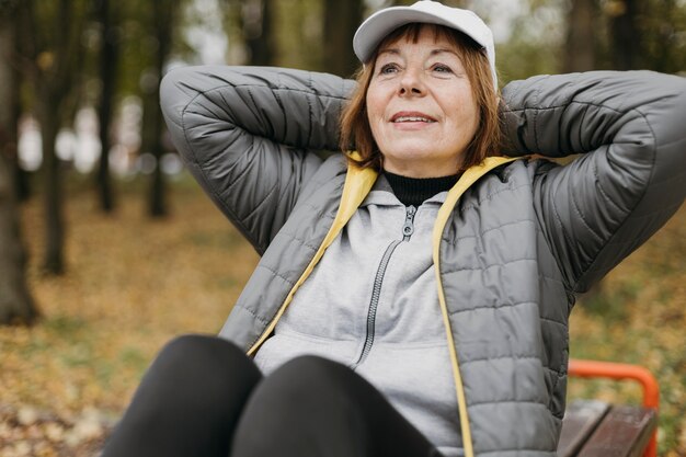 屋外で運動するスマイリー年配の女性