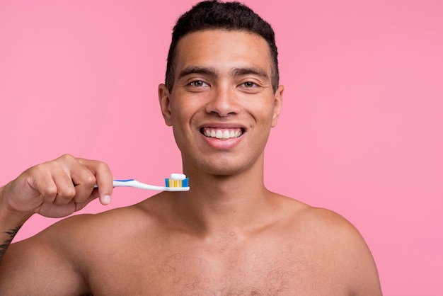 歯ブラシを持っているスマイリー上半身裸の男