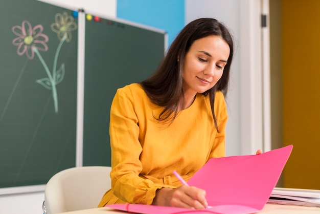 Smiley teacher taking notes