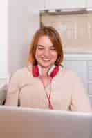 Free photo smiley teacher with headphones holding an online class from home