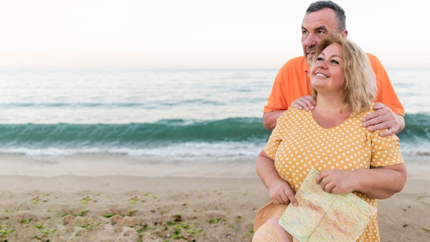 Smiley tourist couple posing at the beach