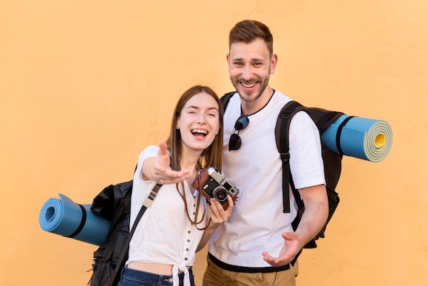 Smiley tourist couple with backpacks and camera