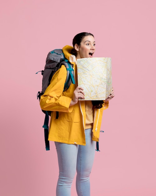 Smiley tourist looking away while holding a map