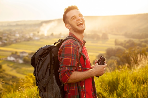 Foto gratuita viaggiatore di smiley con binocolo