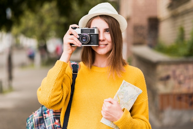 Улыбающаяся путешествующая женщина фотографирует