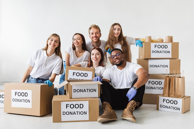 Смайлик-волонтеры позируют вместе с коробками для пожертвований с едой