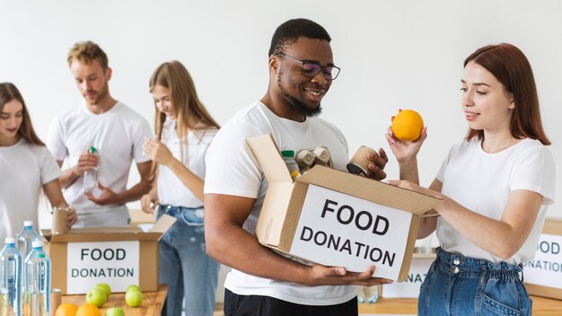 Smiley volunteers preparing food box for donation