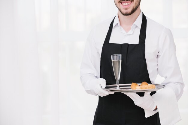 Smiley waiter presenting tray