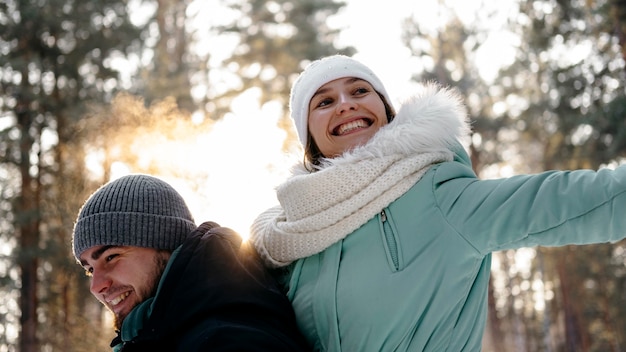 Бесплатное фото Смайлик женщина и мужчина вместе на открытом воздухе зимой