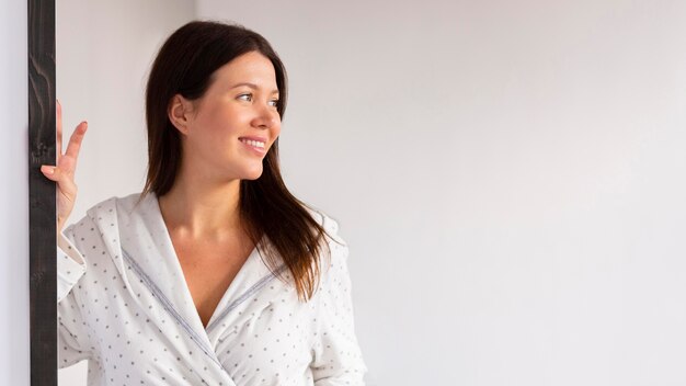 Smiley woman in bathrobe enjoying some self care