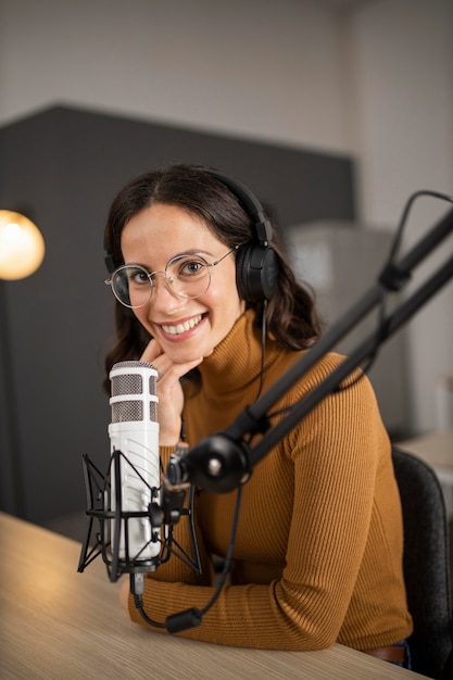 Free photo smiley woman broadcasting on radio with headphones and microphone