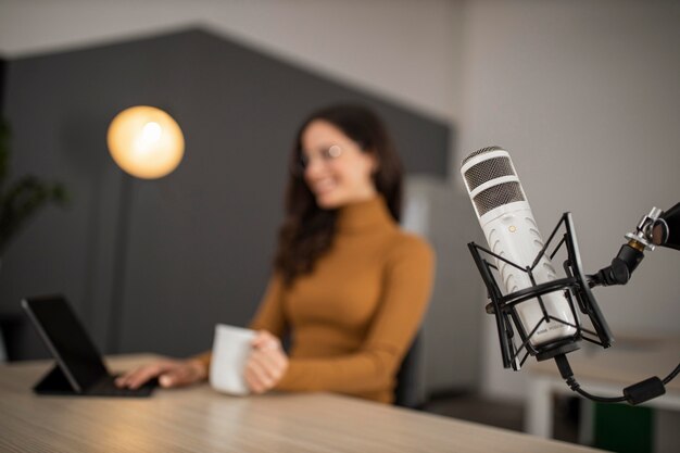 Smiley woman broadcasting on radio with microphone