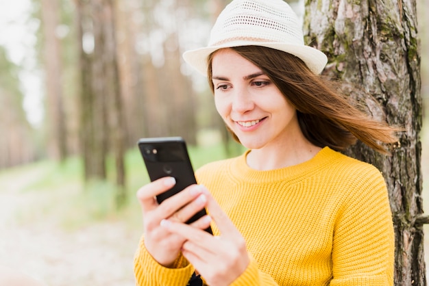 スマイリー女性が彼女の電話をチェック