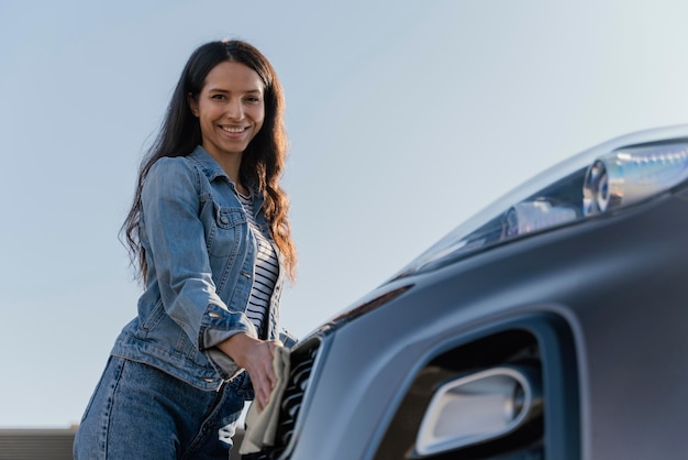 Smiley woman cleaning her car outside