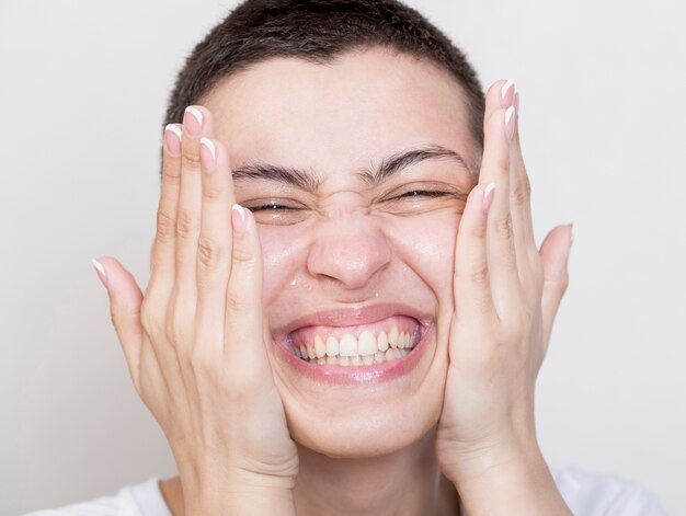 Smiley woman cleaning her face close-up