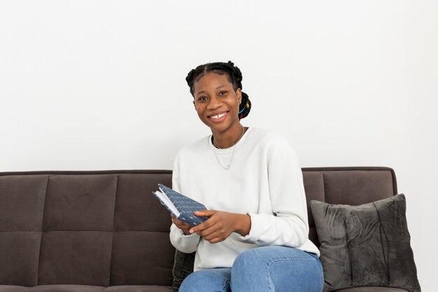 Smiley woman on couch with book