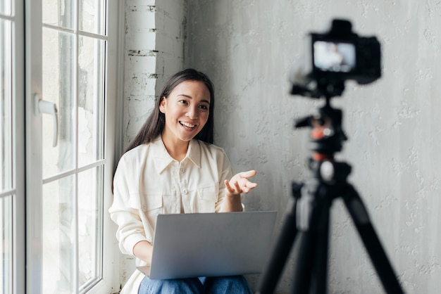 Foto gratuita donna sorridente che fa un vlog al chiuso