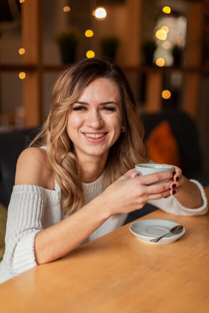 Smiley woman drinking cup of coffee