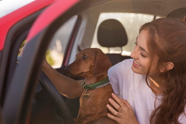 犬と一緒に運転しているスマイリー女性のクローズアップ