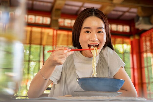 麺を食べるスマイリー女性の正面図