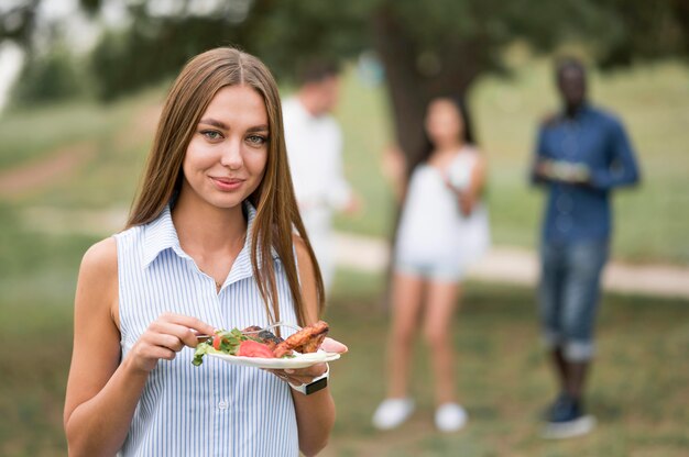 Smiley woman enjoying the food at a barbecue
