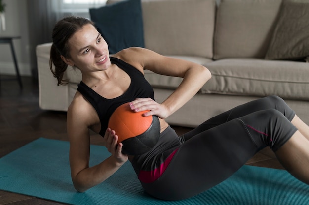 Smiley woman exercising while holding ball