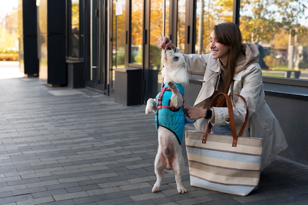 Smiley woman feeding dog full shot