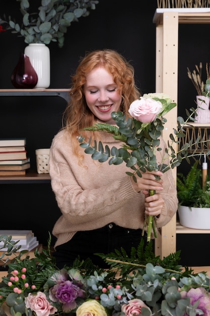 Smiley woman at flowers shop medium shot