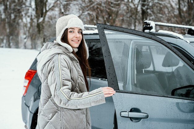 Smiley woman getting back in the car while on a road trip