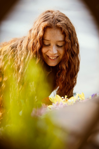 Смайлик женщина получает весенние цветы на открытом воздухе