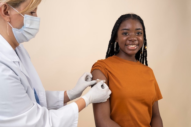 Smiley woman getting a sticker on arm after the vaccine