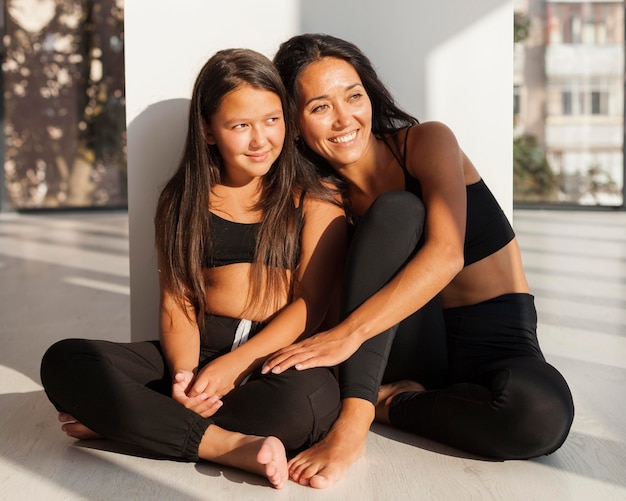 Free photo smiley woman and girl sitting together