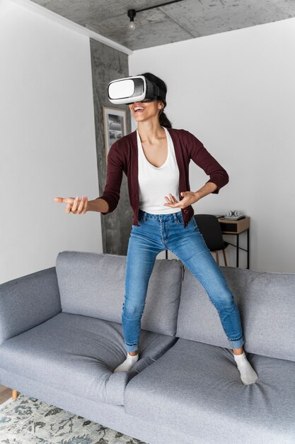 Smiley woman having fun at home with virtual reality headset