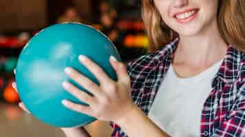 Бесплатное фото Смайлик женщина держит шар для боулинга