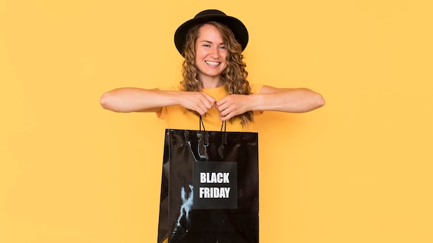 Smiley woman holding black friday shopping bag