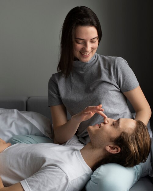 Smiley woman holding boyfriend's head on lap