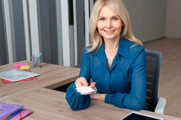 Smiley woman holding business card medium shot