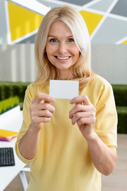 Smiley woman holding business card medium shot