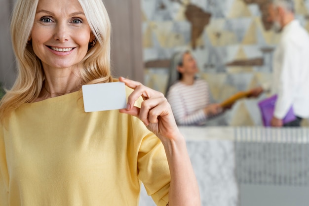 Smiley woman holding business card medium shot