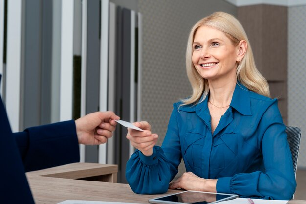 Smiley woman holding business card