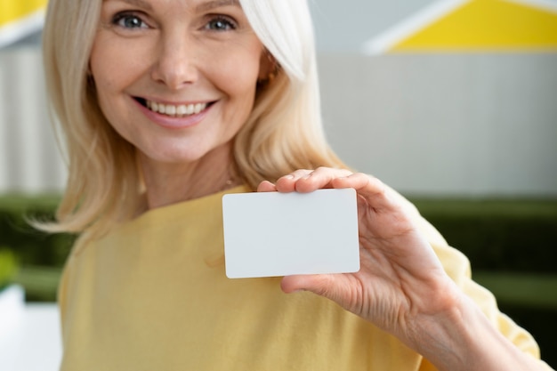 Smiley woman holding business card