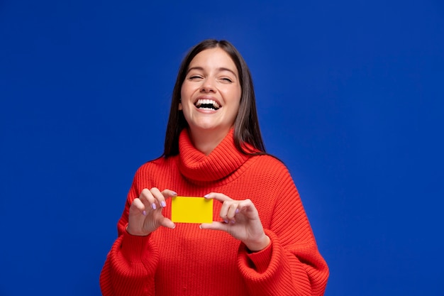 Smiley woman holding card medium shot
