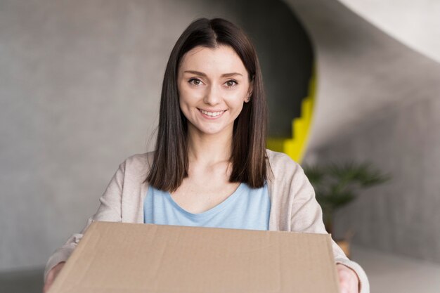 Smiley woman holding cardboard box