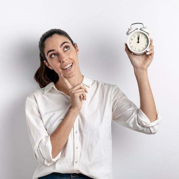 Smiley woman holding clock