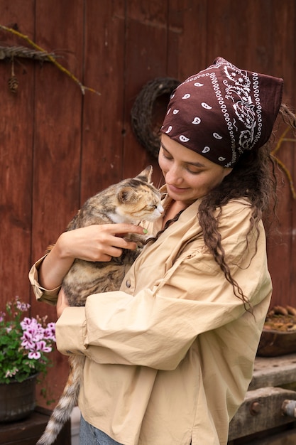 Free photo smiley woman holding cute cat side view